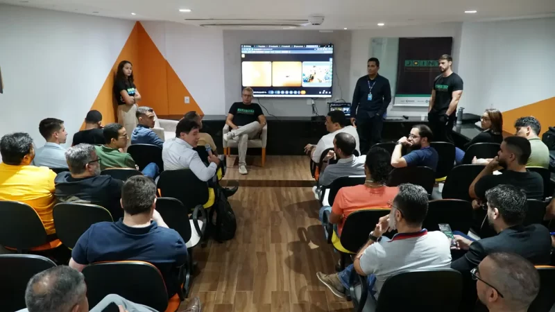 Vista ampla do auditório com Cesar Andrade dialogando com participantes durante dinâmica do programa JoInT+.